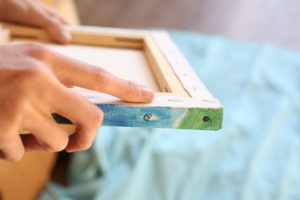 Sanfte Berührung einer bemalten Leinwand im kreativen Prozess