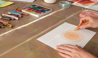 Hand beim intuitiven Malen eines Kreises auf Papier im Workshop