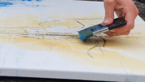 Hand mit Pinsel beim intuitiven Malen auf Leinwand