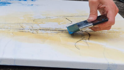 Hand mit Pinsel beim intuitiven Malen auf Leinwand